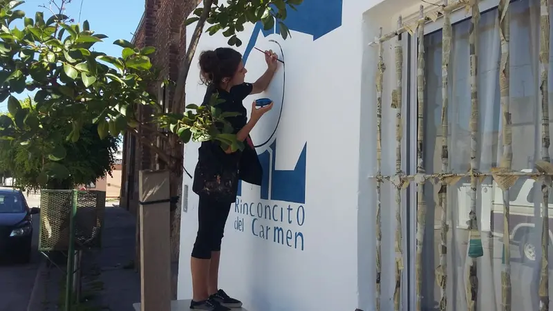 Juli pintando el cartel del Rinconcito del Carmen
